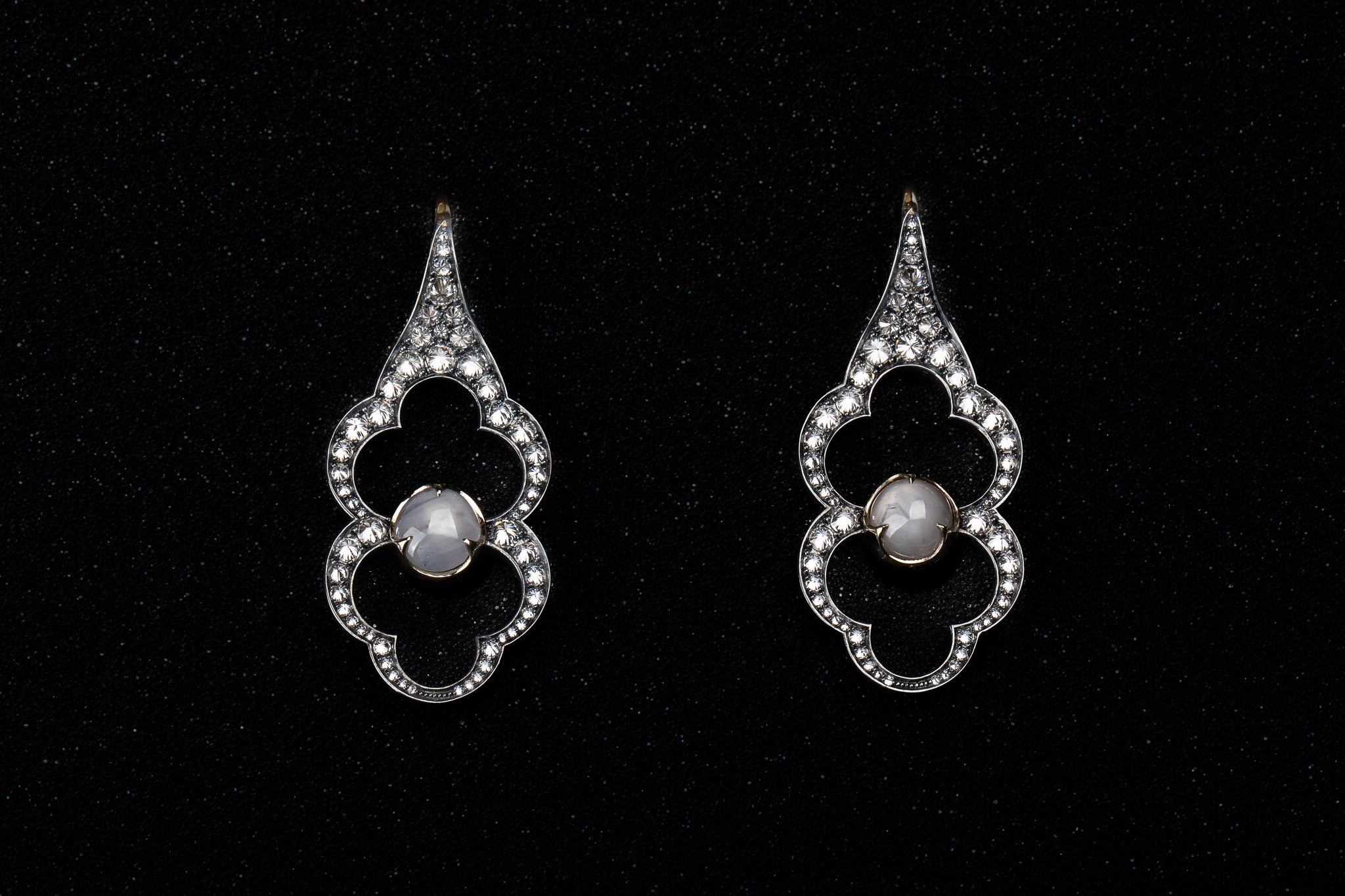 Pair of Parhelion Earrings showing star sapphire asterism and surrounding diamond constellation
