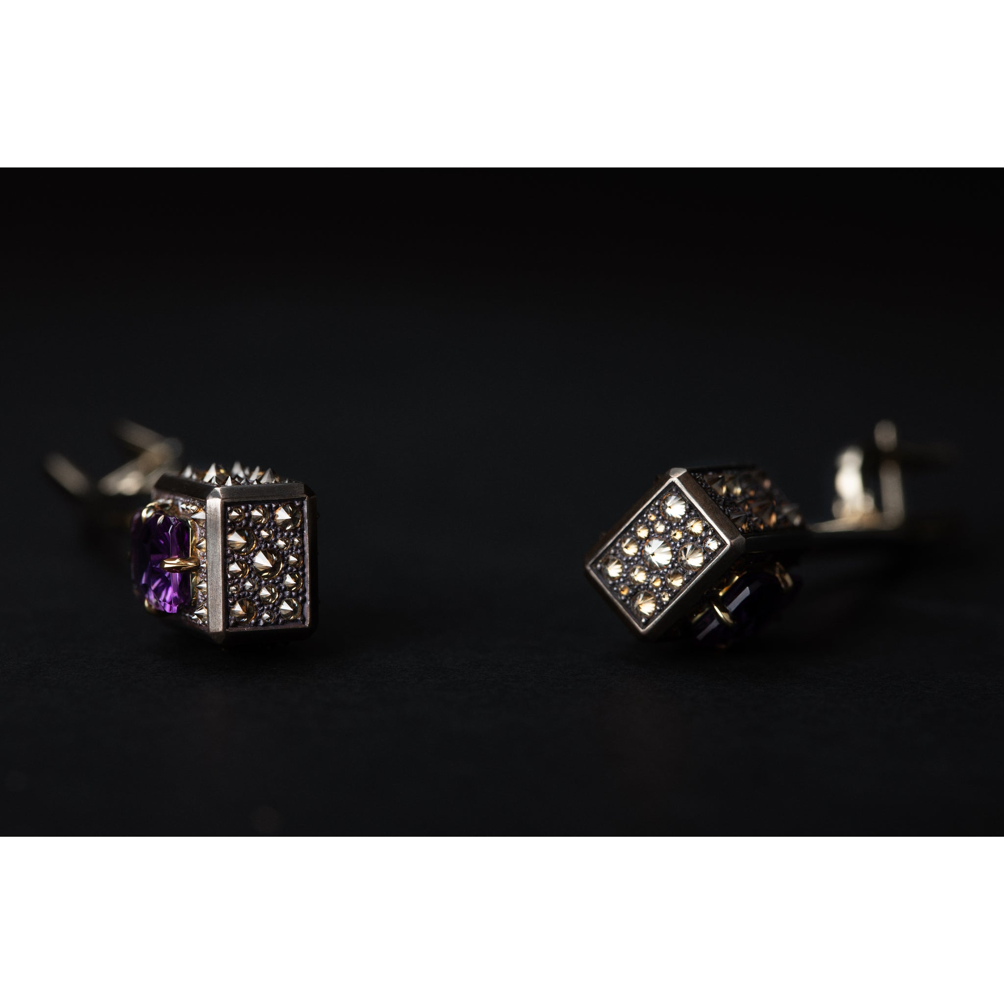 Detail view of the Atlas Spur Earrings revealing patinated shibuichi surface and diamond apertures
