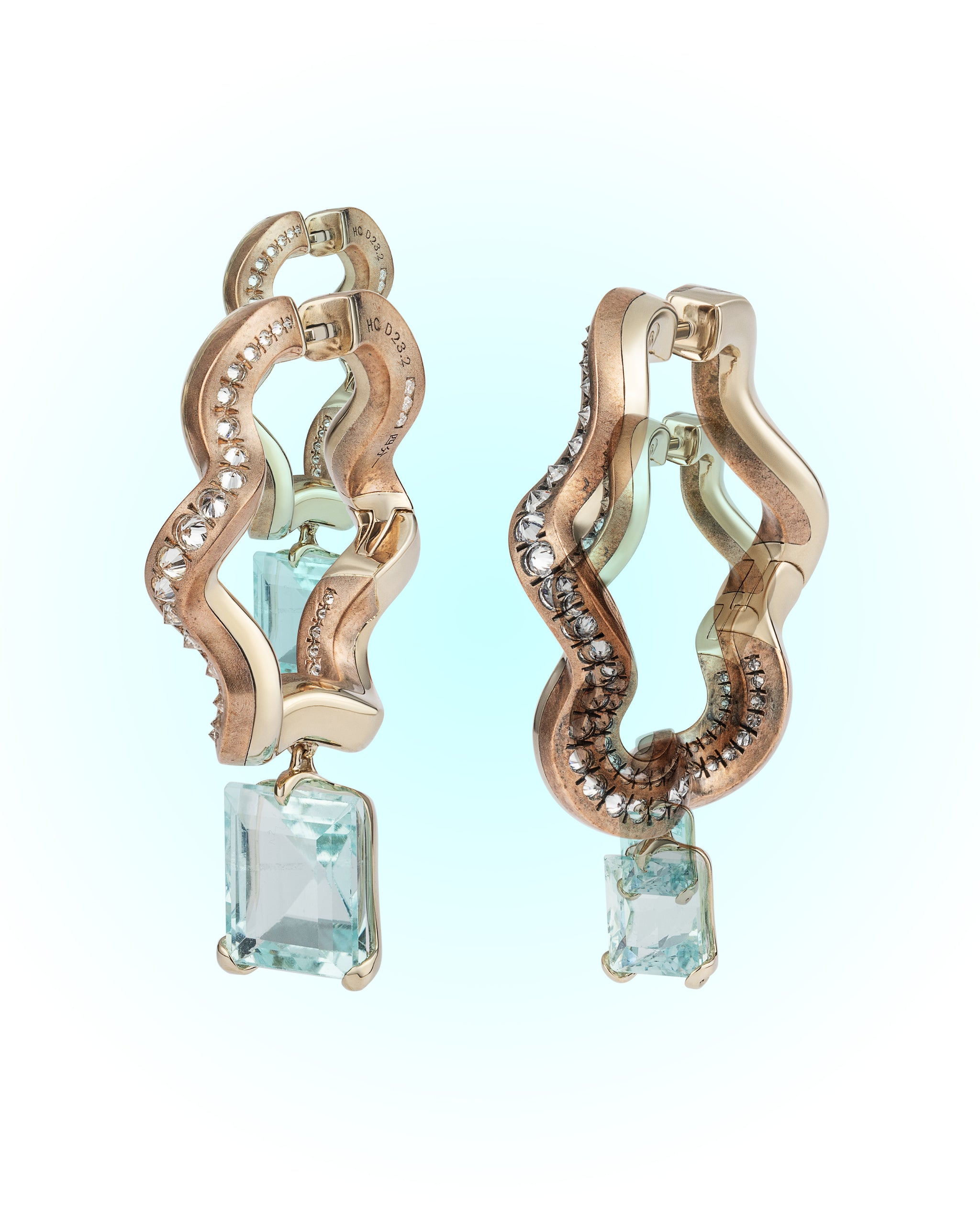Pair of Ebb and Glint Earrings highlighting patinated shibuichi and diamond ribbon setting
