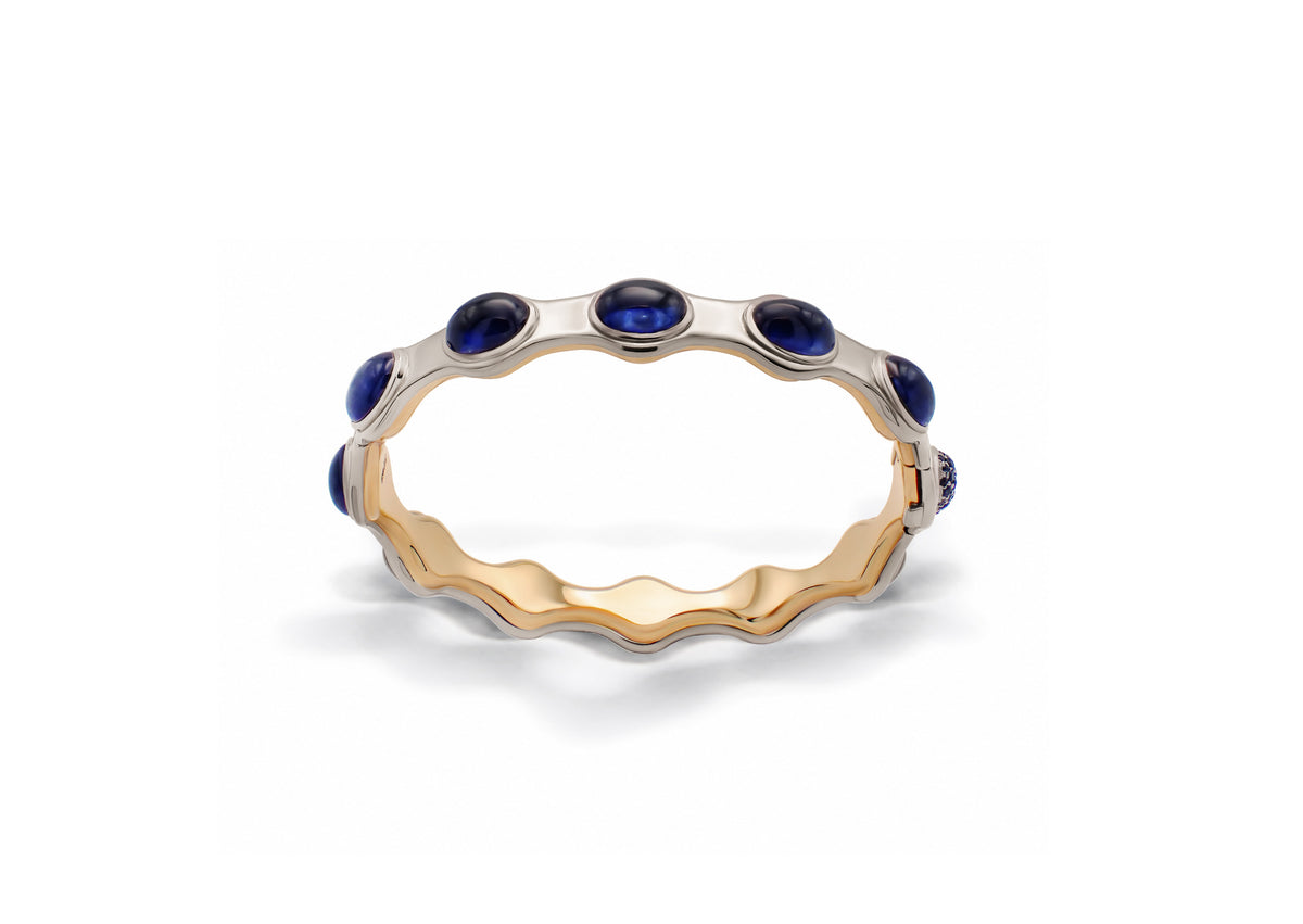 Pleiades Asterism Bracelet shown from the front, oval cabochon and brilliant-cut sapphires arranged in a celestial composition across the gold form.
