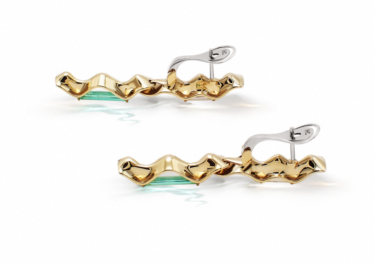 Equinox Auriga Earrings laid flat, showing the full sculptural gold structure and baguette-cut stone setting.