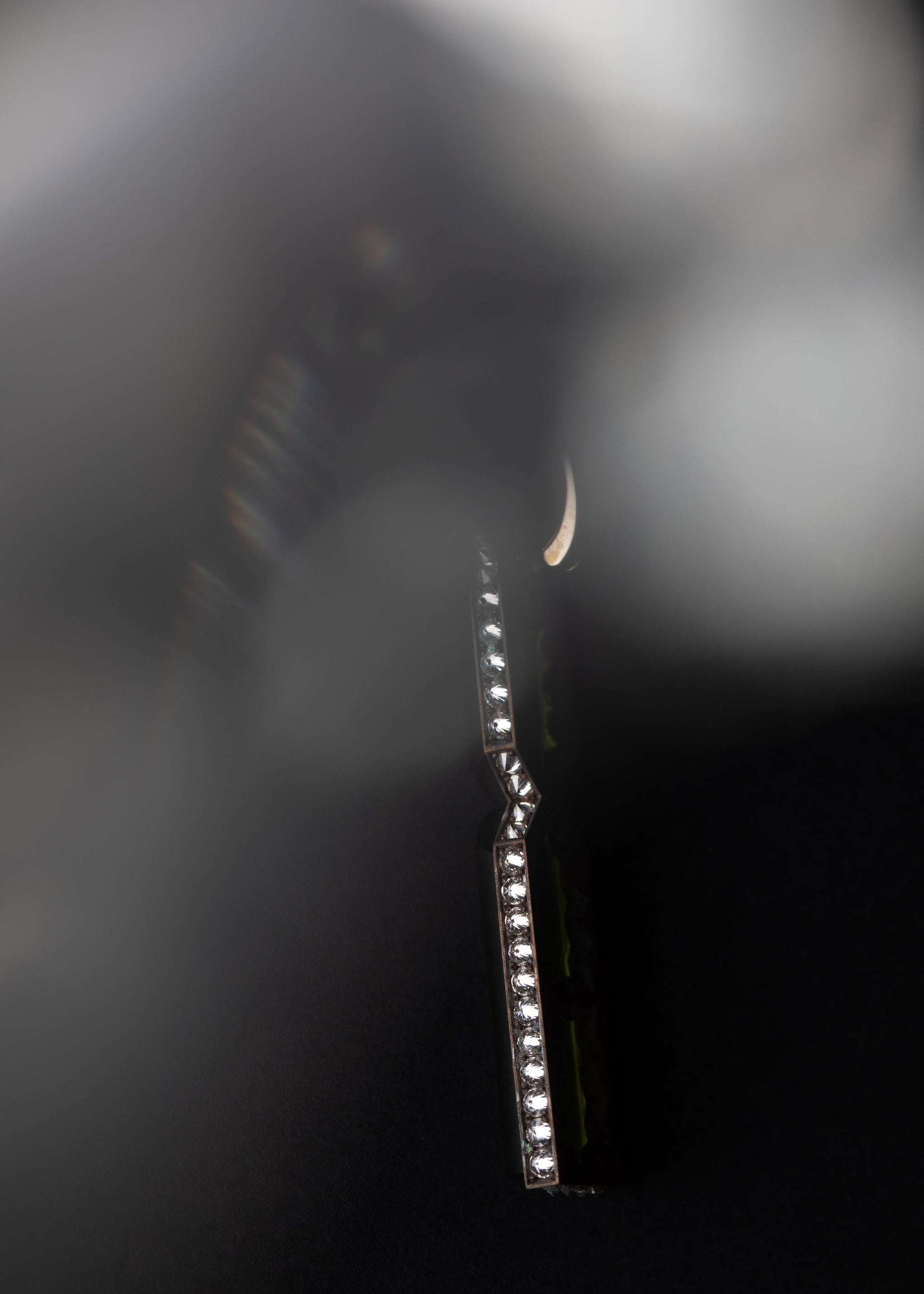 Aleutian Precipice Earring by Hugo Cahill shown suspended, emphasising elongated architectural form

