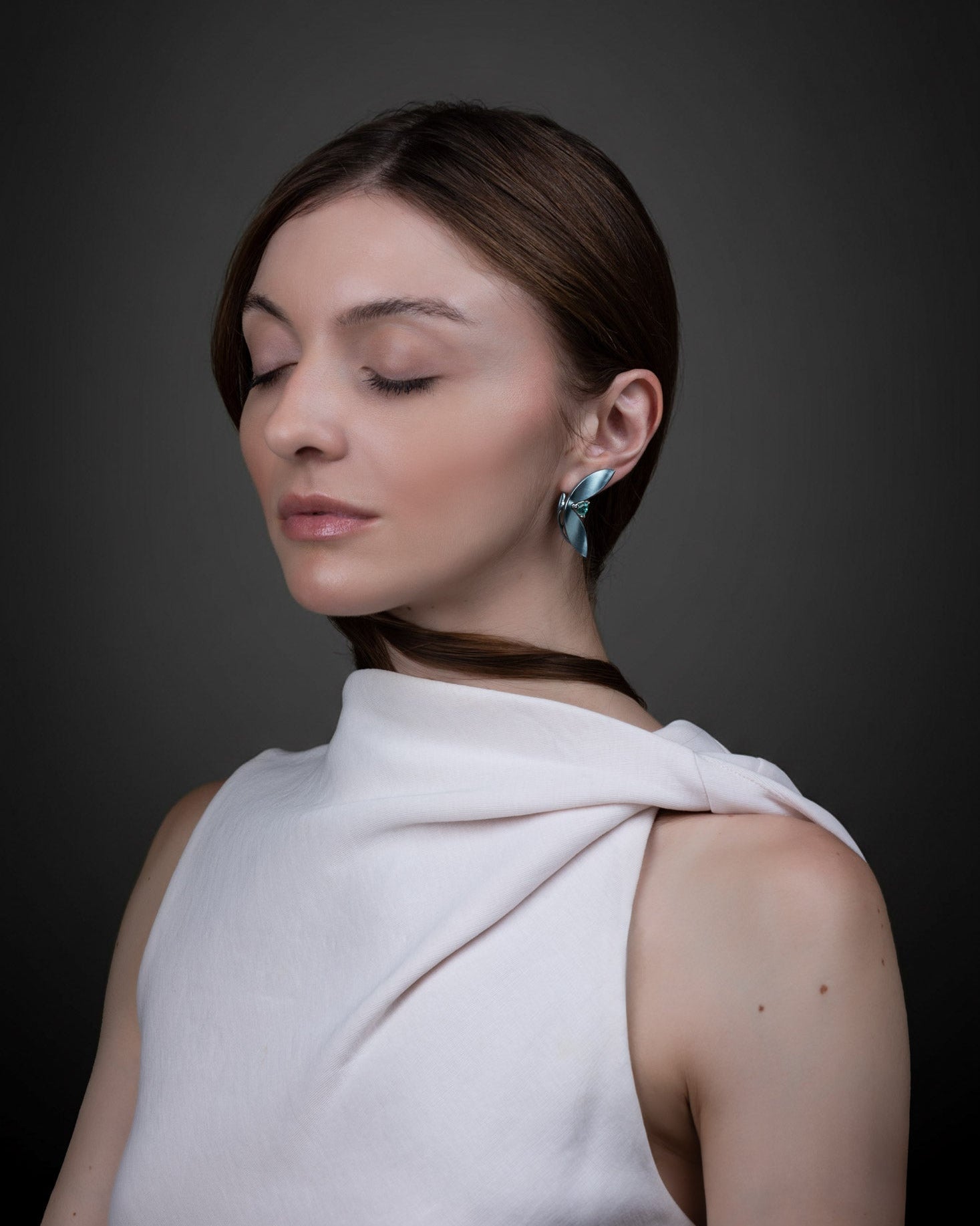 High jewellery earrings by Hugo Cahill, worn, showing scale and suspended sculptural form. Photography by Raquel Pellicano and Humberto Lemos